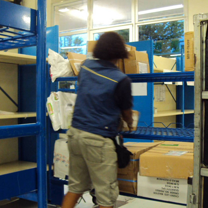 Photographie d'observation d'un utilisateur de l'application Coliposte en train de trier des colis.