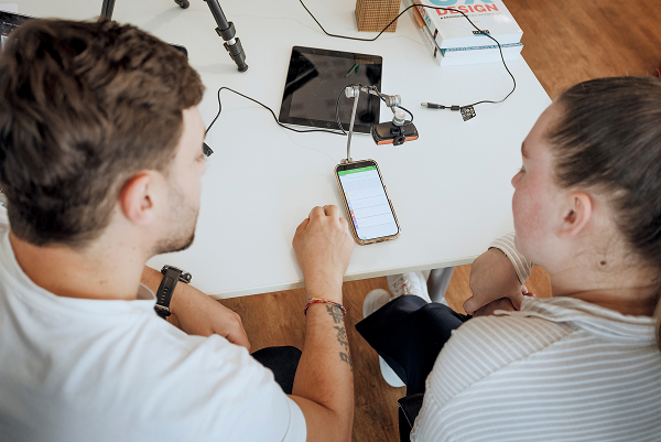 Une stagiaire prépare un test utilisateur sur mobile avec le formateur Usabilis.